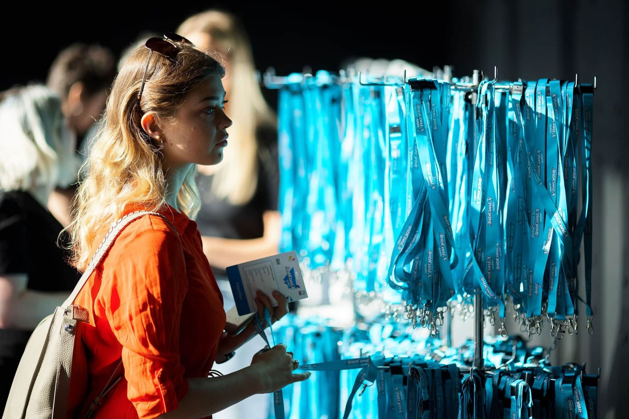 Attendee collecting a branded AntiConLX lanyard at registration