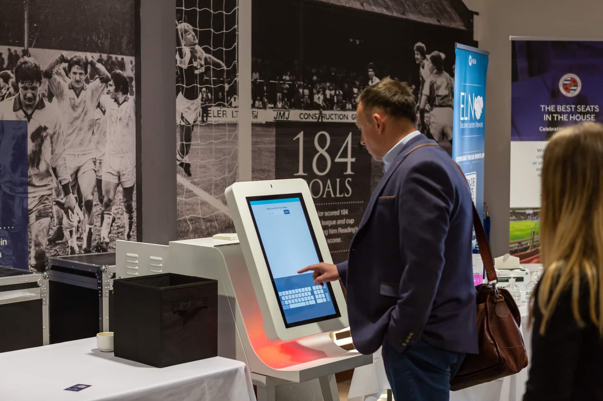 An attendee using the touchscreen on a Glide kiosk