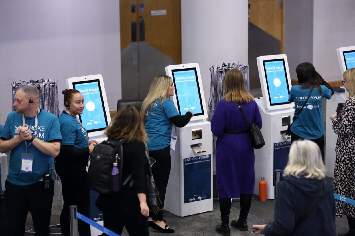 Attendees printing badges at branded Max kiosks at the UK Stroke Forum