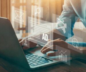 Person typing on a laptop with a translucent overlay of a search bar, an advert panel labelled AD and marketing icons