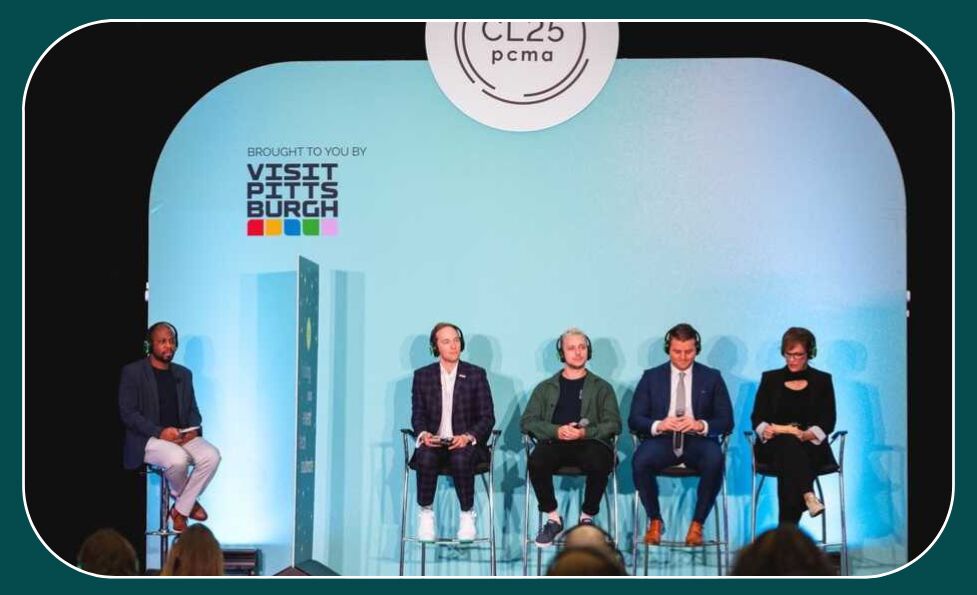 Four panellists wearing headphones on stools with a host opposite, on a stage backed by "Visit Pittsburgh" branding and a CL25 pcma sign