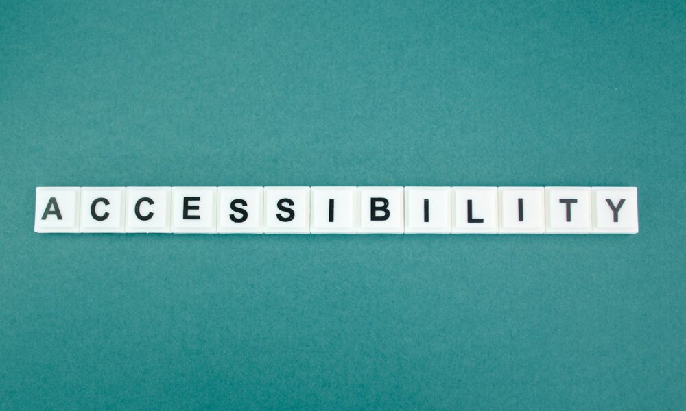 White letter tiles spelling ACCESSIBILITY laid out on a teal background