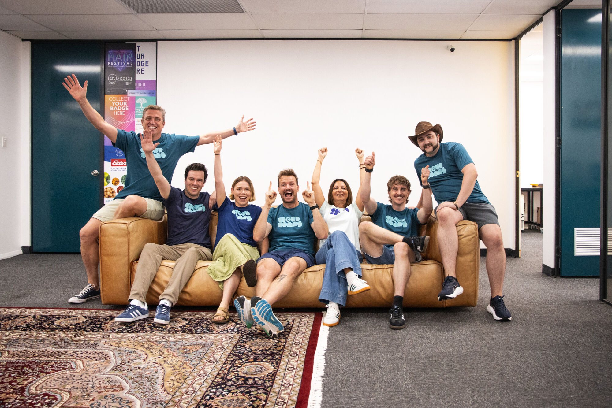 The CrowdComms Australia team celebrating on a sofa after an event