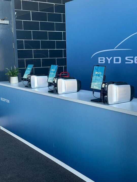 Three Exec stations with tablets and badge printers on the BYD reception desk