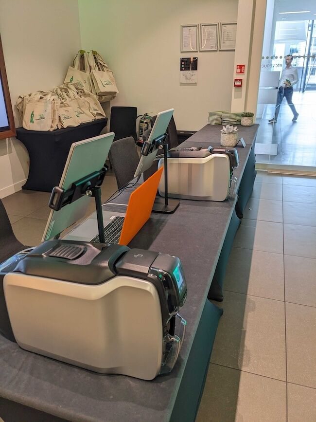A close-up of Exec badge printers and tablet stands on the registration desk