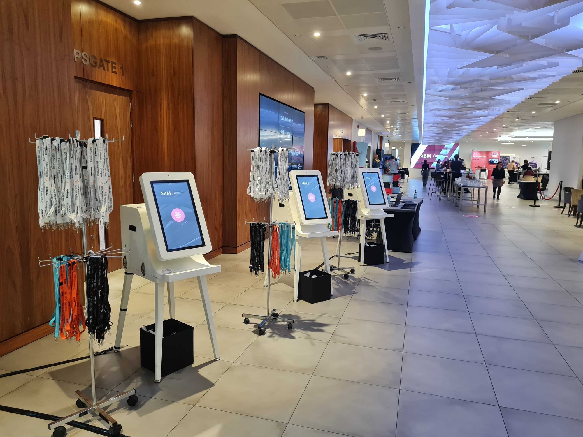 Glide kiosks with lanyard trees lining the concourse at an LBM event