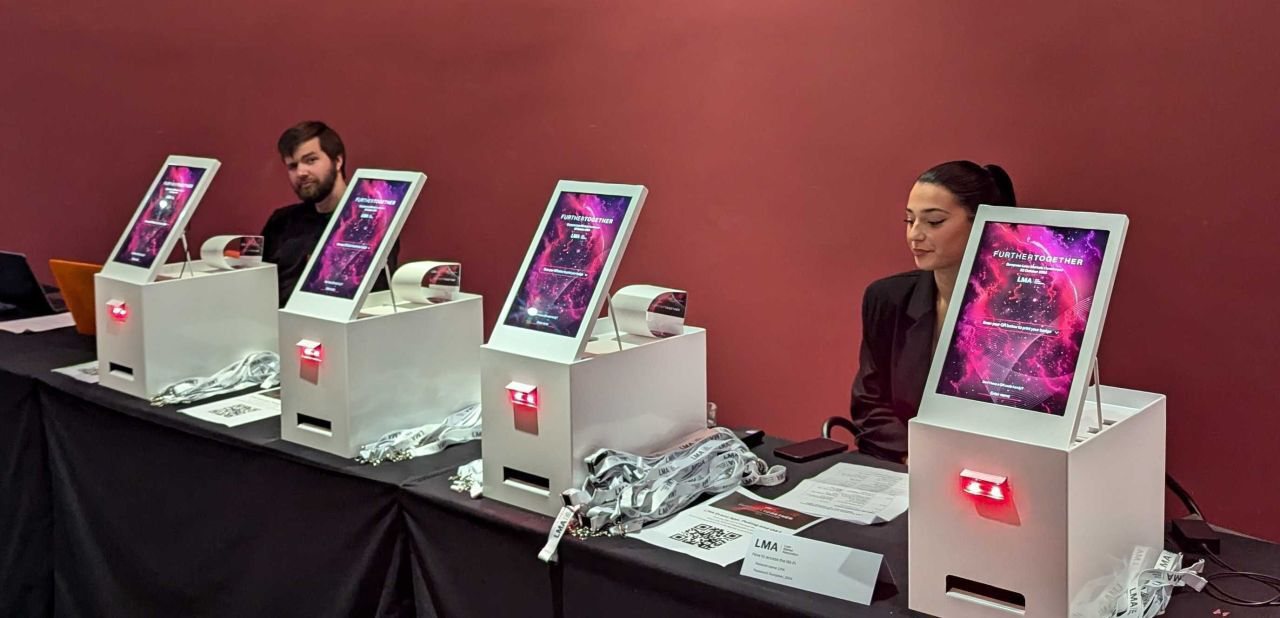Four Mini kiosks on a draped registration table at an LMA conference