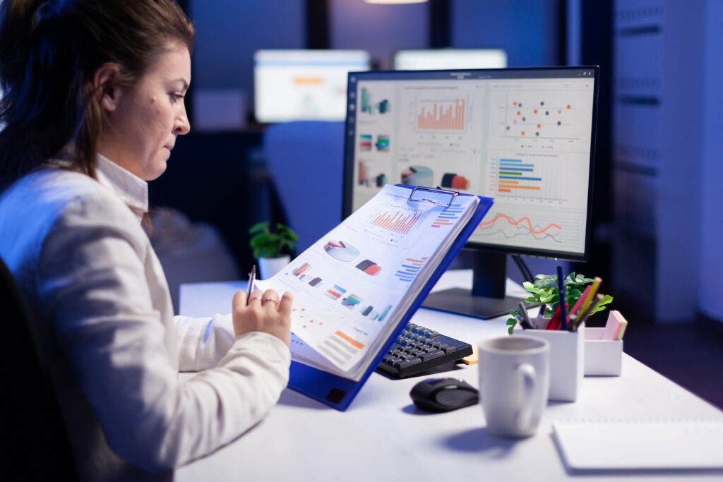 A content creator or marketer working on a structured document, with headings and bullet points visible on screen.